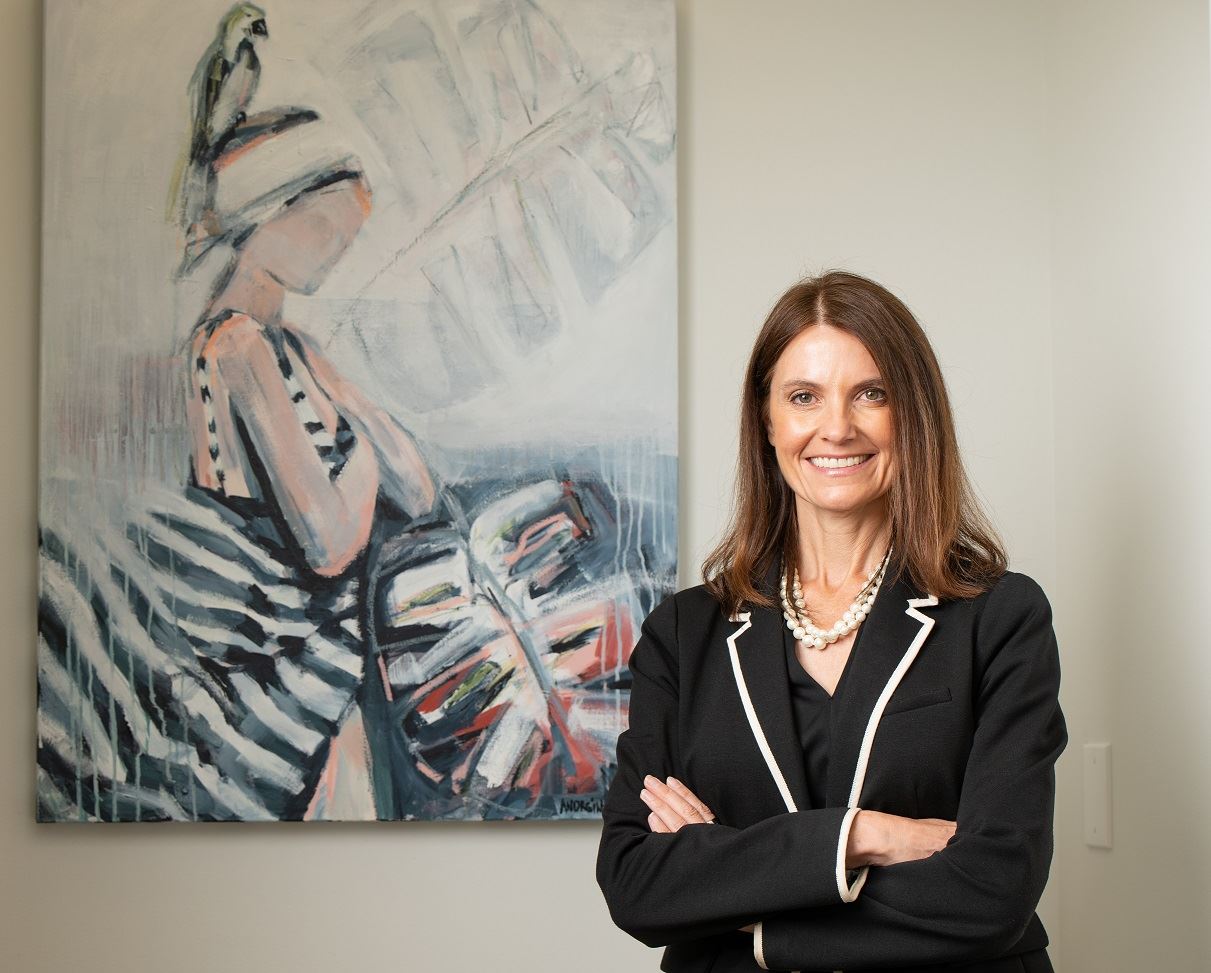 Nichole Corry next to a painting of a woman